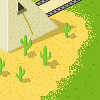 eine Szene in der Wüste: Die Unterseite einer Pyramide mit einem dreieckigen Fenster, aus dem ein Seil hängt. Am Boden ist Sand und mehrere Kakteen. Im Hintergrund läuft eine Straße.